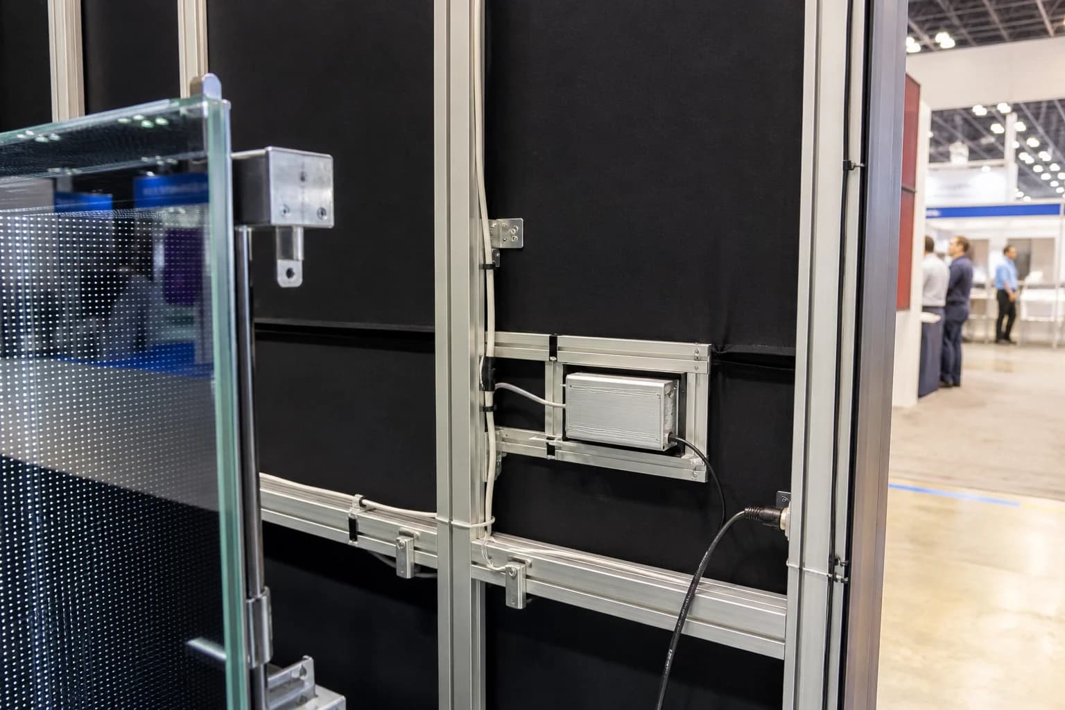 Modular infinity mirror panel hung on a freestanding booth frame with an accessible driver bay and labeled power run