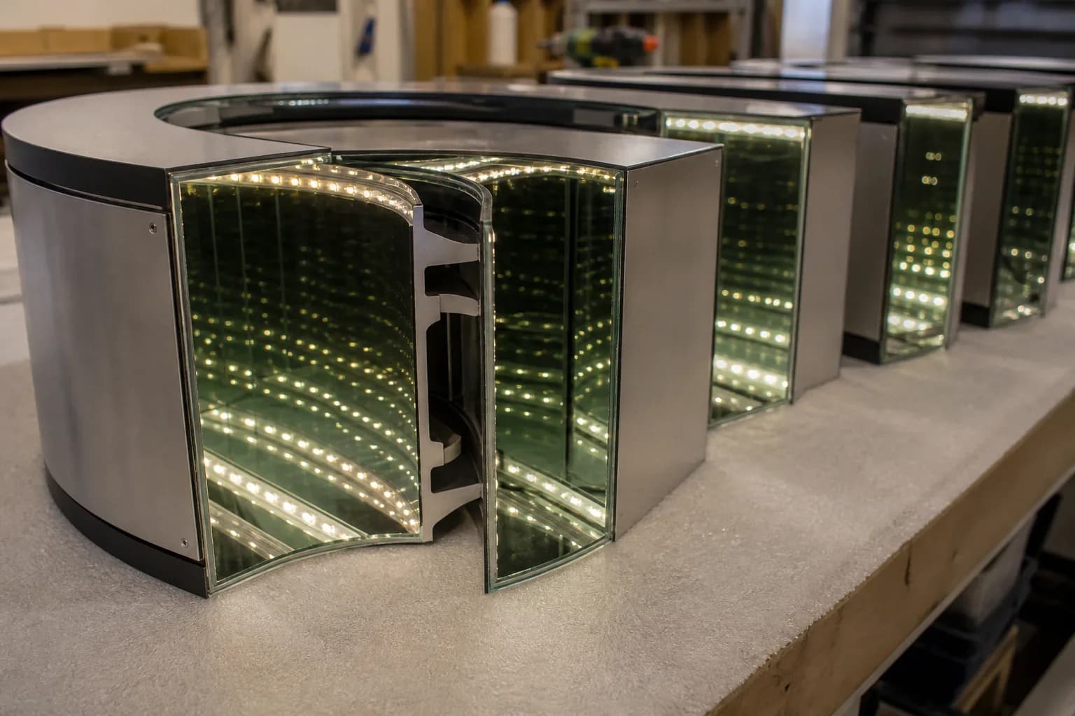 Workshop row of infinity letter shells with matched aluminum returns and warm LED tunnel depth